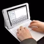 a person typing on a white laptop
