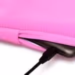 Lyserød laptop sleeve med lynlås og opladerkabel
